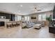 Open-concept living space featuring tile floors, neutral colors, and a comfortable gray sectional couch at 10512 Mann St, Las Vegas, NV 89141