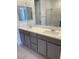Bathroom featuring double sinks with quartz countertops and gray cabinets at 11407 Ethereal Landing Ave, Las Vegas, NV 89138