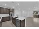 Bright kitchen featuring stainless steel appliances, dark cabinets, and an island with a sink at 11407 Ethereal Landing Ave, Las Vegas, NV 89138