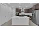 Modern kitchen features stainless steel appliances, brown cabinets and a large white center island at 11407 Ethereal Landing Ave, Las Vegas, NV 89138
