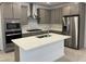 Modern kitchen featuring stainless steel appliances, kitchen island, and gray cabinets at 11407 Ethereal Landing Ave, Las Vegas, NV 89138