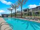Community pool surrounded by palm trees and lounge chairs at 11407 Ethereal Landing Ave, Las Vegas, NV 89138
