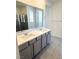 A bright bathroom featuring a double sink vanity, framed mirror and a glass shower enclosure at 11423 Ethereal Landing Ave, Las Vegas, NV 89138
