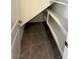 Under-stair storage nook featuring built-in shelves and gray tile flooring for efficient organization at 11423 Ethereal Landing Ave, Las Vegas, NV 89138