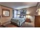 Cozy bedroom with a queen bed, a decorative mirror, and a tree painting at 1150 N Buffalo Dr # 1022, Las Vegas, NV 89128