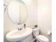 Bright half-bathroom with a pedestal sink, oval mirror, and white walls for a clean and minimalist design at 12536 Blissful Sky St, Las Vegas, NV 89138