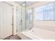 Elegant bathroom featuring a glass-enclosed shower and a soaking tub, designed for relaxation and comfort at 12536 Blissful Sky St, Las Vegas, NV 89138