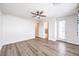 Bright bedroom featuring hardwood floors, a ceiling fan, and ensuite access, offering comfort and convenience at 12536 Blissful Sky St, Las Vegas, NV 89138