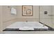 Close up of large soaking tub with a black countertop and neutral colored wall art at 135 E Harmon Ave # 1102, Las Vegas, NV 89109