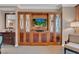 A view of a modern living room with built-in wooden cabinets, TV, and comfortable furniture at 135 E Harmon Ave # 1102, Las Vegas, NV 89109