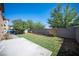 Spacious backyard featuring artificial turf, a concrete patio, and mature trees at 1405 Gilbert Creek Ave, North Las Vegas, NV 89031