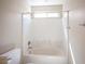 Clean bathroom with a tub and shower combination, tiled walls and a window for natural light at 1405 Gilbert Creek Ave, North Las Vegas, NV 89031