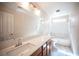 Bright bathroom featuring a vanity with countertop, large mirror and a tub with shower at 1405 Gilbert Creek Ave, North Las Vegas, NV 89031