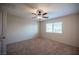 This bedroom features neutral walls, carpet, a ceiling fan, and a window for natural light at 1405 Gilbert Creek Ave, North Las Vegas, NV 89031