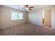 The carpeted bedroom includes a ceiling fan and large window for ample natural light at 1405 Gilbert Creek Ave, North Las Vegas, NV 89031