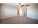 Carpeted bedroom with a ceiling fan, a door, and access to a walk-in closet at 1405 Gilbert Creek Ave, North Las Vegas, NV 89031