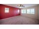 Bedroom with three windows, carpeted floors, neutral and red paint at 1405 Gilbert Creek Ave, North Las Vegas, NV 89031