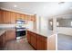 Well-lit kitchen featuring granite countertops, stainless steel appliances, and wood cabinets at 1405 Gilbert Creek Ave, North Las Vegas, NV 89031