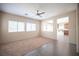 Bright living room with neutral carpet, tile accents, and a ceiling fan at 1405 Gilbert Creek Ave, North Las Vegas, NV 89031