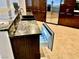 This gourmet kitchen has stainless steel appliances, dark wood cabinets, and an beverage refrigerator built into the island at 1915 Hazeltine Ct, Henderson, NV 89074