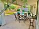 Charming covered patio features stone flooring, seating, and a view of the sparkling blue pool at 1915 Hazeltine Ct, Henderson, NV 89074