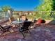 Inviting outdoor patio with stylish stone flooring, seating, and views of the green lawn and mountains at 1915 Hazeltine Ct, Henderson, NV 89074