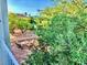 High angle of outdoor stone patio including seating with a lush green border and neighborhood views at 1915 Hazeltine Ct, Henderson, NV 89074