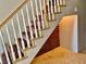 Carpeted staircase with white railing and a custom wine rack at 1915 Hazeltine Ct, Henderson, NV 89074