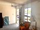A sparse living room with an orange chair and a view to the outside through a door with bars at 212 Hinkle St, Las Vegas, NV 89107