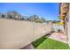 A cozy backyard features faux grass, a brick patio, and a white fence for privacy at 219 Cordelia Cove Ave # 513, Henderson, NV 89011