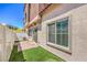 A cozy backyard features faux grass, a brick patio, and a white fence for privacy at 219 Cordelia Cove Ave # 513, Henderson, NV 89011