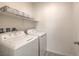 Functional laundry room with washer, dryer, and a shelf for storage at 219 Cordelia Cove Ave # 513, Henderson, NV 89011