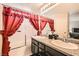 Bathroom featuring dual sinks, granite countertops, and stylish red curtains at 2341 Steinke Ln, Las Vegas, NV 89108