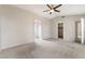 Open bedroom featuring neutral walls, carpet, doorways to other rooms, and a ceiling fan at 2407 Belt Buckley Dr, Henderson, NV 89002