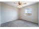 Bright bedroom featuring neutral walls, carpet, a ceiling fan, and a window with a neighborhood view at 2407 Belt Buckley Dr, Henderson, NV 89002