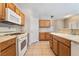 Well-lit kitchen featuring updated appliances, tile floor, and wood cabinetry at 2407 Belt Buckley Dr, Henderson, NV 89002