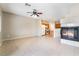 Open-concept living space with tile floors, fireplace, and adjacent kitchen with white appliances at 2407 Belt Buckley Dr, Henderson, NV 89002