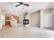 Bright and open living space with fireplace, tile floors, adjacent kitchen, and ceiling fan at 2407 Belt Buckley Dr, Henderson, NV 89002