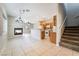 Open-concept living space with tile floors, fireplace, staircase, and adjacent kitchen at 2407 Belt Buckley Dr, Henderson, NV 89002