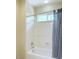 Bright bathroom featuring a shower-tub combo with shower curtain and built-in window at 2451 Tour Edition Dr, Henderson, NV 89074