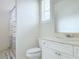 Well-lit bathroom featuring white fixtures, a sink vanity, and a shower with patterned curtains at 2451 Tour Edition Dr, Henderson, NV 89074