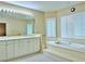 Bathroom featuring a soaking tub, dual vanity with modern fixtures at 2451 Tour Edition Dr, Henderson, NV 89074