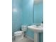Powder room showcasing a stylish blue tiled wall, pedestal sink and modern fixtures at 2451 Tour Edition Dr, Henderson, NV 89074