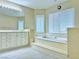 Elegant bathroom featuring a soaking tub, dual vanity, and plantation shutters at 2451 Tour Edition Dr, Henderson, NV 89074