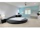 Modern bedroom with a round bed, white textured accent wall, and cozy crib area at 2451 Tour Edition Dr, Henderson, NV 89074