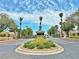 Elegant community entrance with palm trees, lush landscaping, and a security gate for added privacy at 2451 Tour Edition Dr, Henderson, NV 89074