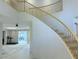 Open foyer with curved staircase and views into the bright and airy living spaces beyond at 2451 Tour Edition Dr, Henderson, NV 89074