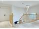 Upstairs hallway featuring a modern chandelier and natural wood railings with multiple doors at 2451 Tour Edition Dr, Henderson, NV 89074