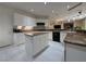Kitchen featuring an island, black appliances, stone countertops and bright white cabinets at 2451 Tour Edition Dr, Henderson, NV 89074