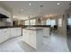 Open kitchen features a kitchen island, bright white cabinets and hardware, stone countertops and stainless appliances at 2451 Tour Edition Dr, Henderson, NV 89074